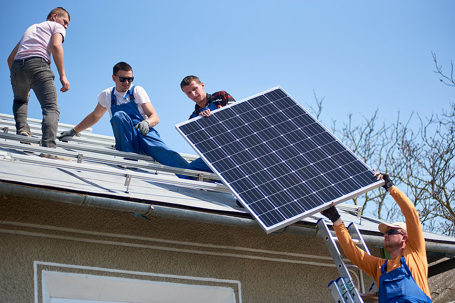 worker handing the solar panel