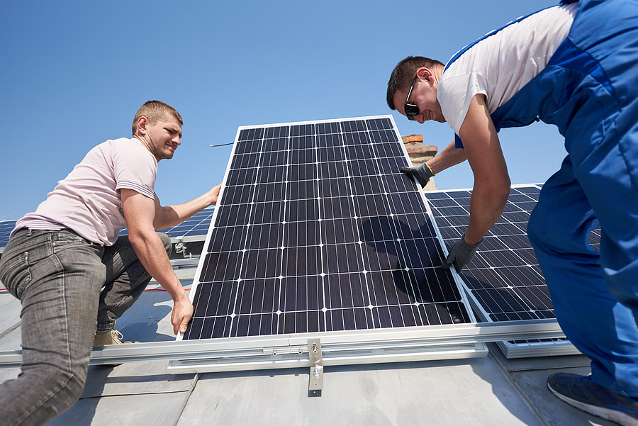two workers installing the solar panel